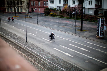 Cyclists on a path near the River Main, a route normally busy with people but currently nearly empty as people heed calls to restrict their movements during the coronavirus crisis.