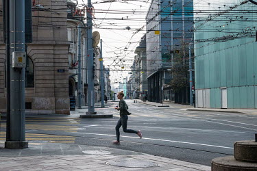 A woman jogging through downtown Geneva, where the banking district meets the main shopping street, deserted of people and traffic on a Saturday afternoon.   Two weeks into Switzerland's lockdown, i...