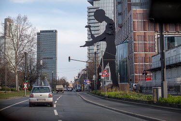 The Hammering Man sculpture, close to the new Messeturm (exhibition tower) building at the Frankfurt Trade Fair. The ruch hour traffic is unusually light due to the coronavirus crisis as people stay h...