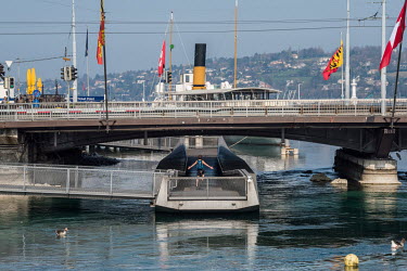 A cyclist rides along a pontoon beneath the Pont du Mont Blanc bridge, at the point where the lake empties into the Rhone in the city centre.  Two weeks into Switzerland's lockdown, in the face of the...