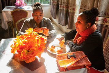 Two women sit together at a table in a hotel in the port of Gorogora on Lake Tana.
