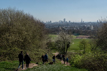 People walk through Hampstead Heath, a large area of park and lakes in north London, prior to the government's implementation of an enforceable lockdown. People ignoring the government's advice on soc...