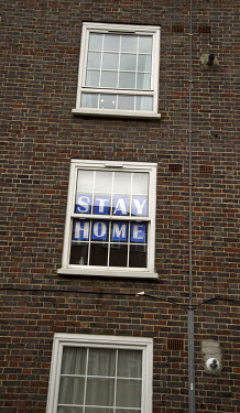 A sign displayed in the window of a flat in Hackney urging people to 'stay home'.