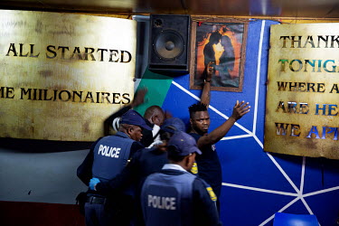 Police arrest a man in a bar in Hillbrow.
