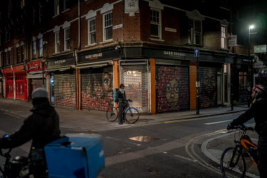 Delivery bicycle riders meet at a crossroads on Brick Lane in east London. With all restaurants closed for diners, delivery drivers are being kept busy. The following day, on the 25 March 2020, the Co...