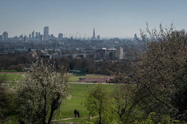 People walk through Hampstead Heath, a large area of park and lakes in north London, prior to the government's implementation of an enforceable lockdown.