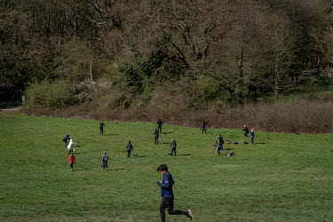 A man runs past a 'group collective meditation practice' on Hampstead Heath. Although the group is observing social distancing, it was people ignoring the government's advice on social distancing led...