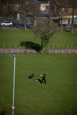 A man playing golf outside during the coronavirus lockdown in the Ancoats district.