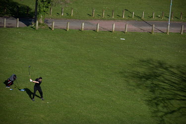A man playing golf outside during the coronavirus lockdown in the Ancoats district.