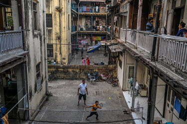 A family play badminton in a yard outside a residential block as the authorities enforce a strict lockdown in the face of the coronavirus threat.