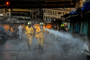 Fire brigade personnel spray sodium hypochlorite (bleach) solution to disinfect the streets and kill the coronavirus.