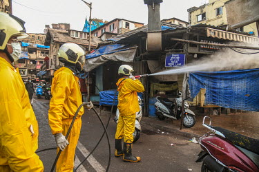Fire brigade personnel spray sodium hypochlorite (bleach) solution to disinfect the streets and kill the coronavirus.