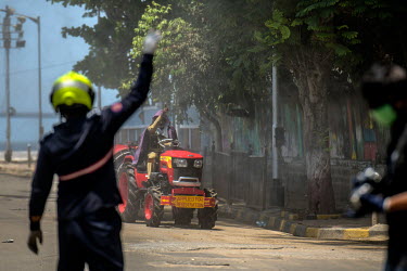 A fire brigade personnel calls a BMC sanitisation worker to spray disinfectant outside a residential building for infected COVID-19 patients.