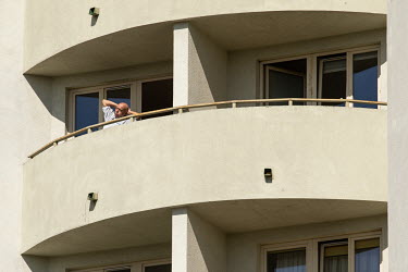 A man exercises on the balcony of his apartment while confined at home during the coronavirus lockdown.