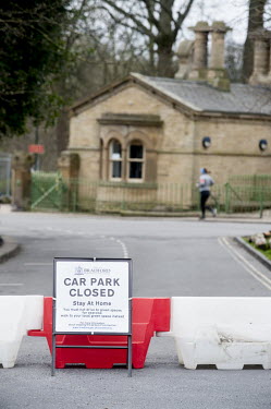 A sign and barriers barring entry to a car park outside Roberts Park in Saltaire, a popular tourist destination. As part of the UK's social distancing and coronavirus lockdown measures it instructs pe...