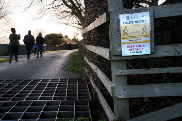 A sign on a public footpath encouraging people exercising in rural green spaces to practice social distancing as part of the measures to prevent spread of the coronavirus.