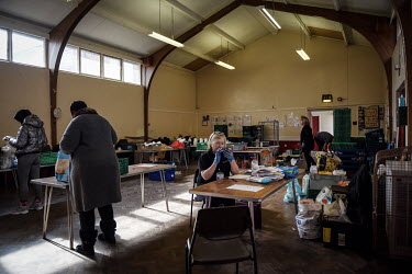 Volunteer Carole Rowland checks messages and deals with the paperwork for a client while her team prepare food parcels for those in need who are attending the Newcastle West End Foodbank. The West End...