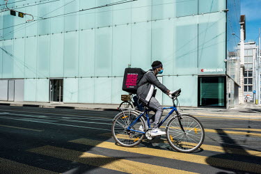 A Smood food delivery rider, cycles through the banking district which would normally be very busy on a Friday lunchtime but, five weeks into the coronavirus lockdown, is almost deserted.