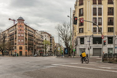 A bicycle delivery rider on Goya Street at its junction with Alcala Street, usually a very busy spot, but nearly empty during the confinement imposed by the state of alert declared by the Government o...