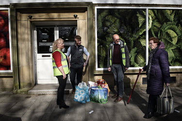 Volunteers wait for the community bus to arrive after buying shopping from the local supermarket to make up parcels that they will deliver to the town's elderly residents. Rothbury has a significant e...