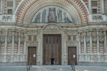 A woman kneels to pray at the doors of Westminster Cathedral in central London on Good Friday. This year all churches are closed to the public due to the coronavirus lockdown.
