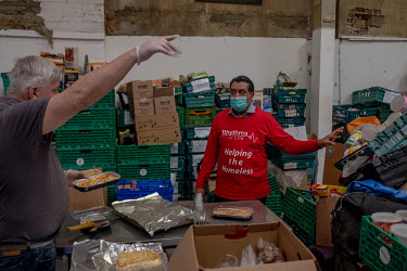 Andrew Faris, the founder of Rythms of Life, a charity that helps London's homeless, works with a volunteer to cook and pack food that will be distributed to rough sleepers in central London. the gove...