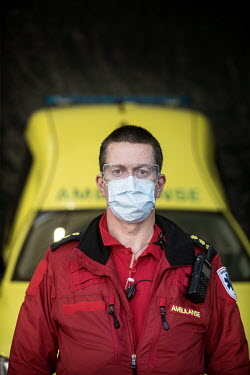 A paramedic in the city of Drammen wearing a mask while transporting patients in an ambulance.