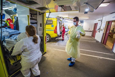 Paramedics wearing personal protective equipment (PPE) move a patient from an ambulance at Drammen hospital.