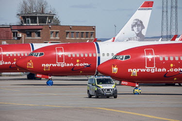 A police vehicle patrols Gardermoen Airport where the aircraft have been mothballed and grounded due to the coronavirus crisis.   Norwegian authorities introduced measures to combat the coronavirus...