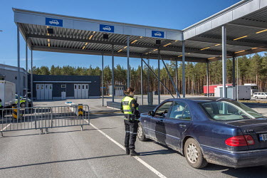 A police woman talks with a car driver at the closed border with Sweden.