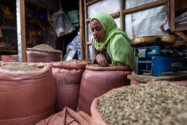 A woman selling spices in a market.