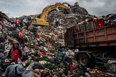 Rubbish pickers, avoiding the diggers operating all around them, search for recyclable plastic and other items amongst a freshly dumped load of waste brought in from Jakarta at the Bantar Gabang landf...