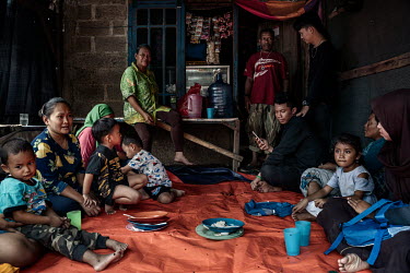 Parents and children rest after lunch at a makeshift kindergarten for children of rubbish pickers and sorters living in Ciketing Udik, a village of recyclers and recycling businesses near the Bantar G...