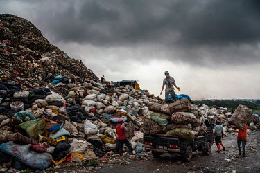A man stands on top of a pile of sacks of recycled items at the Bantar Gabang landfill. A constant flow of trucks brings fresh loads of rubbish from Jakarta to the site where rubbish pickers descend o...