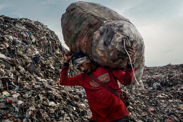 Rubbish pickers search for recyclable plastic and other items amongst a freshly dumped load of waste brought in from Jakarta at the Bantar Gabang landfill.