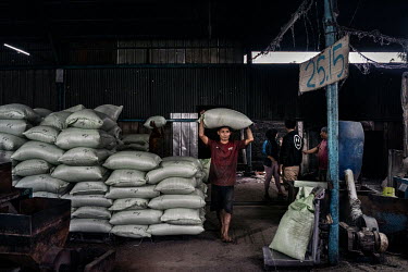 Workers at the Aneka Plastics factory in Ciketing Udik, a village of recyclers near the Bantar Gabang landfill site, carry sacks of plastic pellets made from waste plastic bags collected by rubbish pi...