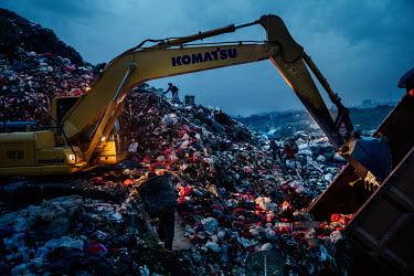 Rubbish pickers, avoiding the diggers operating all around them, search for recyclable plastic and other items amongst a freshly dumped load of waste brought in from Jakarta at the Bantar Gabang landf...