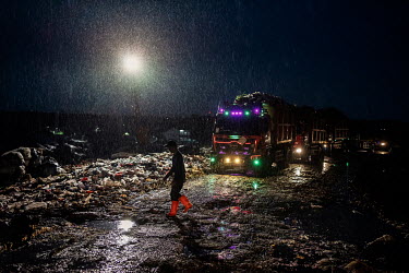 Rain pours on to a queue of trucks, part of a constant stream bringing rubbish from Jakarta to the giant Bantar Gabang landfill. Rubbish pickers search the site night and day for recyclable plastic an...