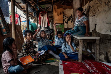 The children of rubbish pickers and sorters attend a class at an informal school in Ciketing Udik, a village of recyclers and recycling businesses near the Bantar Gabang landfill site.
