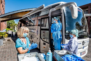 Medical technicians at a mobile testing laboratory prepare to take samples from staff and residents at a nursing home, which will be tested in the especially equipped vehicle for SARS-CoV-2, the coron...