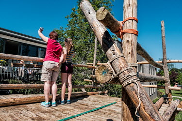 During a visit to Muriel's father Bob, she and daughter Amina stand on a platform, constructed by local scouts outside the De Wingerd care home that raises visitors to the same level as the residents.