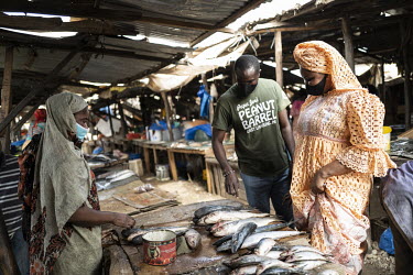 Bara Tambedou with his wife Mame Sey buy fish a market for their meal breaking the fast on the first day of Ramadan. This year the family will celebrate Ramadan at home due to the coronavirus lockdown...