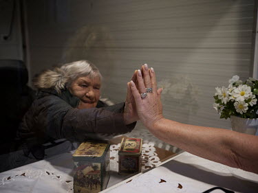 Thea Vroomen, 78, who lives in a care home, puts her hand next to her daughter's hand. Her daughter Karin Berenschot-Vroomen, 52 and her husband Jan Berenschot-Vroomen, 61 are meeting Thea in a mobile...