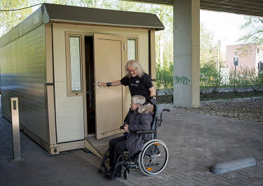 Thea Vroomen, 78, lives in a care home. She is being escorted to a mobile meeting room where she can safely meet her daughter Karin Berenschot-Vroomen, 52 and her husband Jan Berenschot-Vroomen, 61. I...