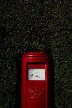 A red letterbox surrounded by a border hedge in Leith.  Hedges offer increased privacy, isolating the homeowner and emphasising the division of public and private space. Where boundaries between prope...