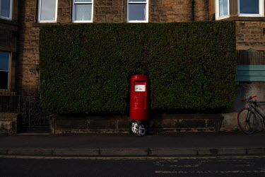 A red letterbox surrounded by a border hedge in Leith.  Hedges offer increased privacy, isolating the homeowner and emphasising the division of public and private space. Where boundaries between prope...