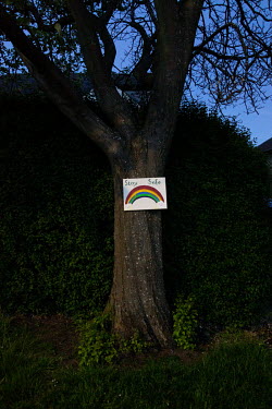A 'stay safe' sign nailed to a tree in Blackhall. The rainbow became a symbol used by the public to support health workers during the coronavirus pandemic.  Hedges offer increased privacy, isolating...