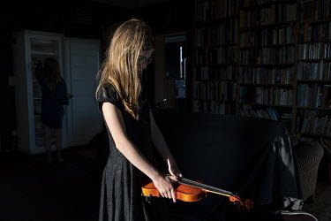 Suzanne rehearses on her violin. She's tired of her father photographing her.  When Belgium followed much of the rest of the world into lockdown, Nick Hannes, like many Panos photographers, found hims...