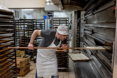 A man baking Ramadan Pide, a flat bread popular at Iftar, the breaking of the fast at the end of the day, in the Yasar Halim bakery in Green Lanes, home to a large Turkish and Kurdish community.