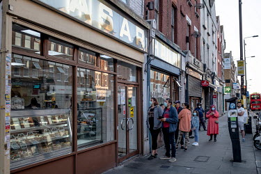 People queue to buy cakes and sweets for Iftar, the breaking of the Ramandan fast at the end of the day, at the Yasar Halim bakery in Green Lanes, which has a large Turkish and Kurdish community.